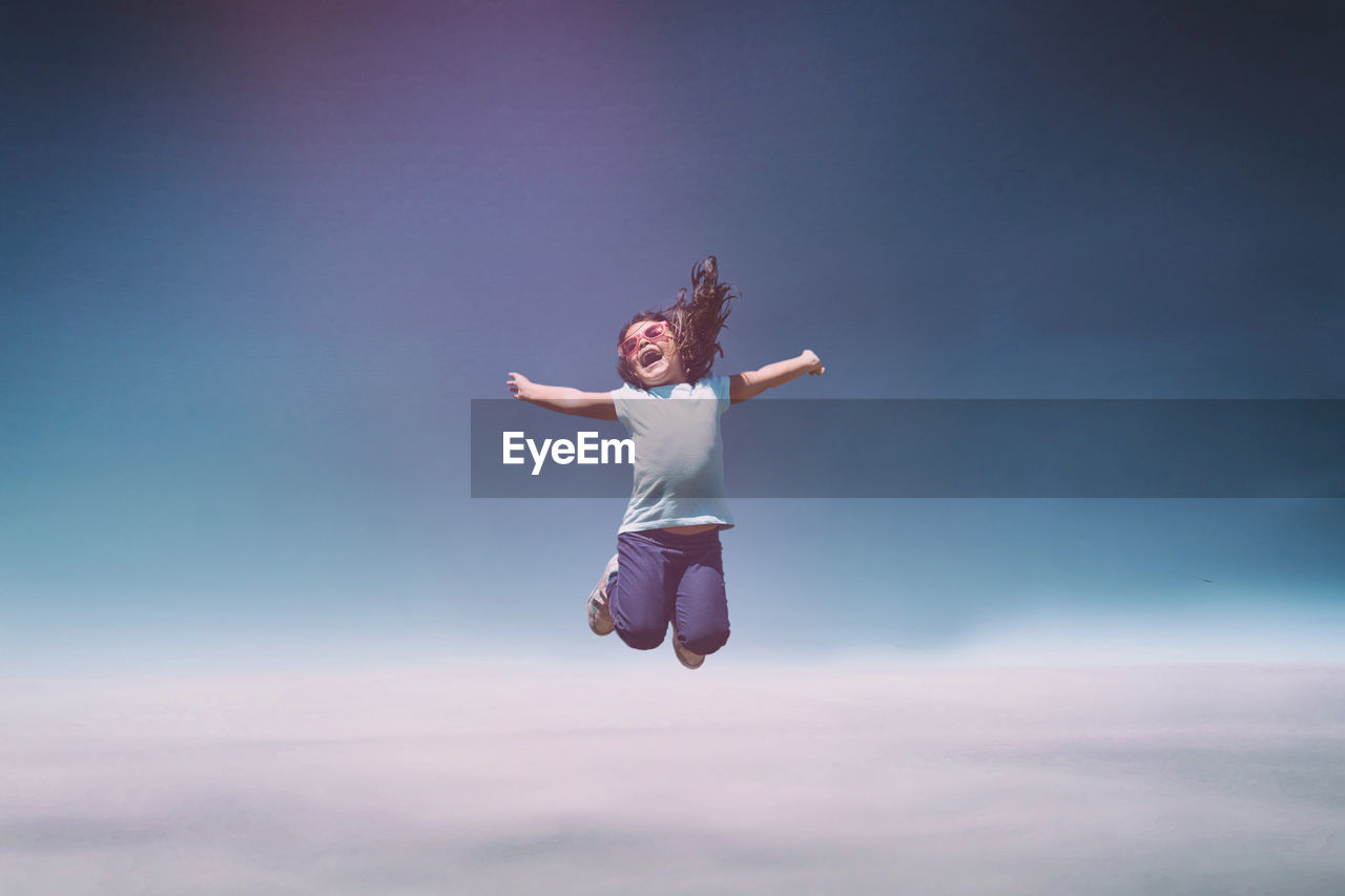 Girl jumping against clear sky