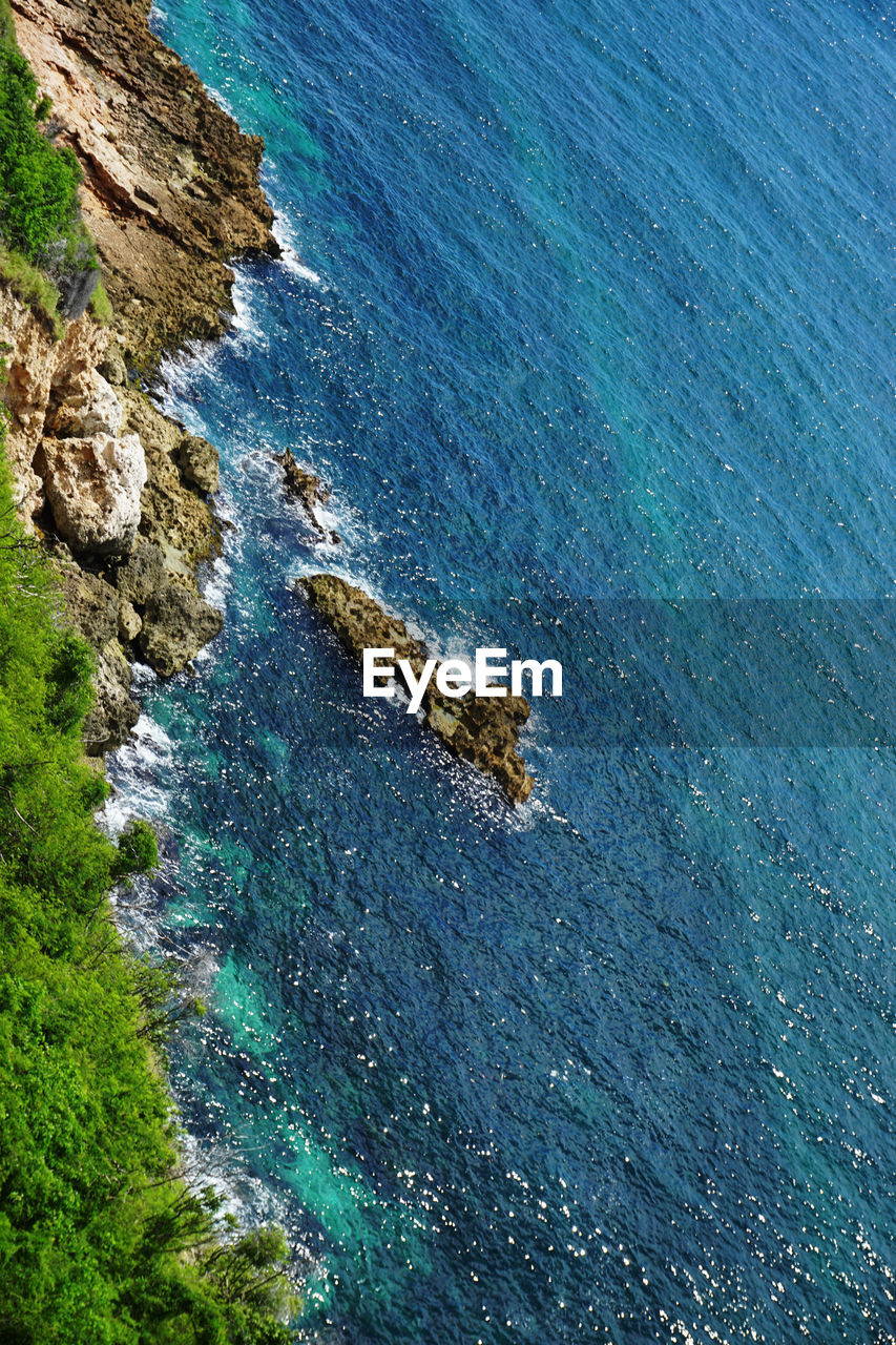 HIGH ANGLE VIEW OF ROCK FORMATIONS AT SEA