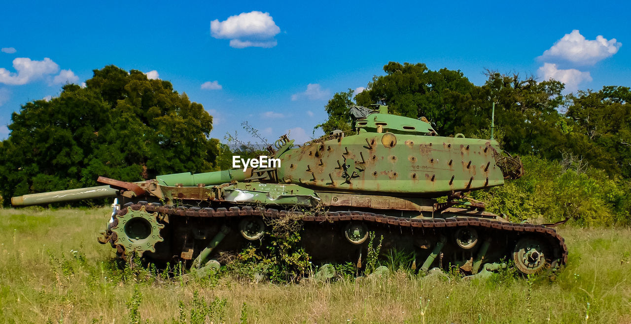 Armored tank on field against sky