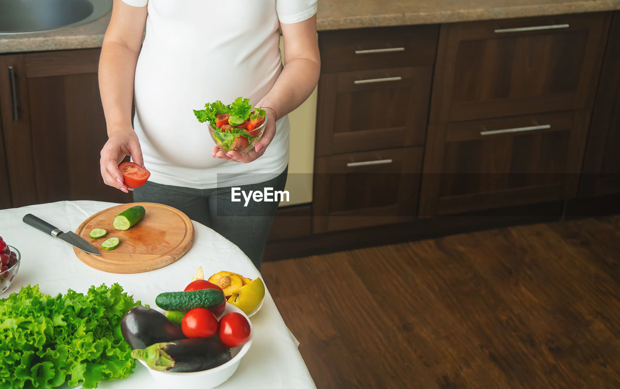 midsection of woman with food on table