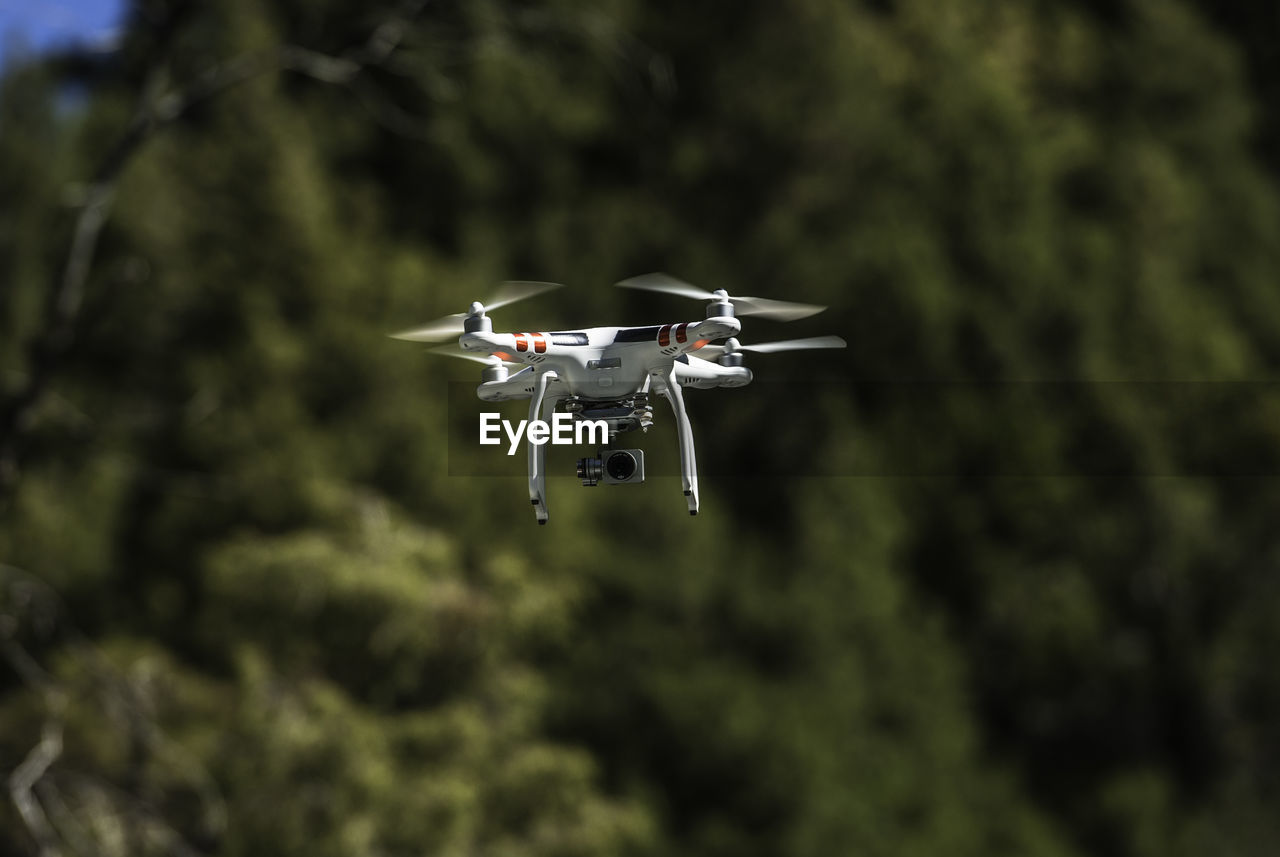 Close-up of drone flying against sky