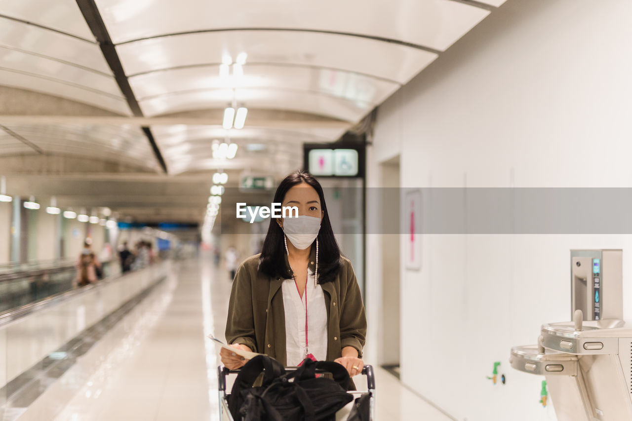 Coronavirus asian woman with surgical mask walking in the airport