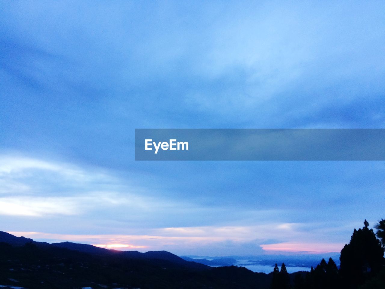 SCENIC VIEW OF MOUNTAINS AGAINST CLOUDY SKY