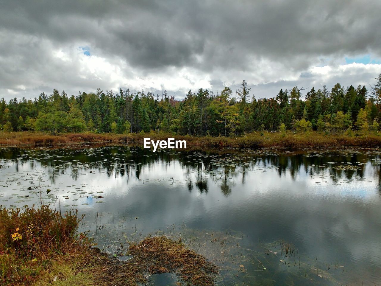 SCENIC VIEW OF LAKE AGAINST CLOUDY SKY