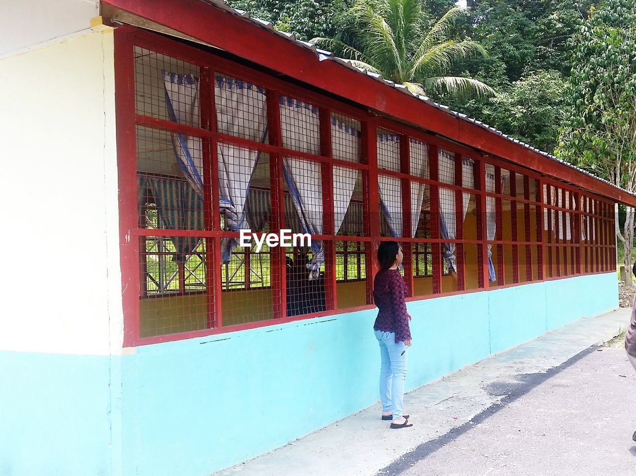 Rear view of woman standing by building