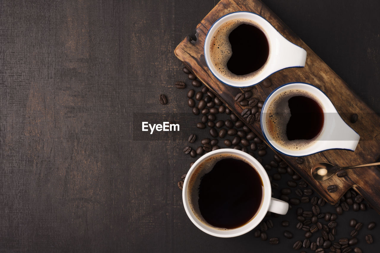 Coffee cup with black coffee on a wooden table. top view with copy space.