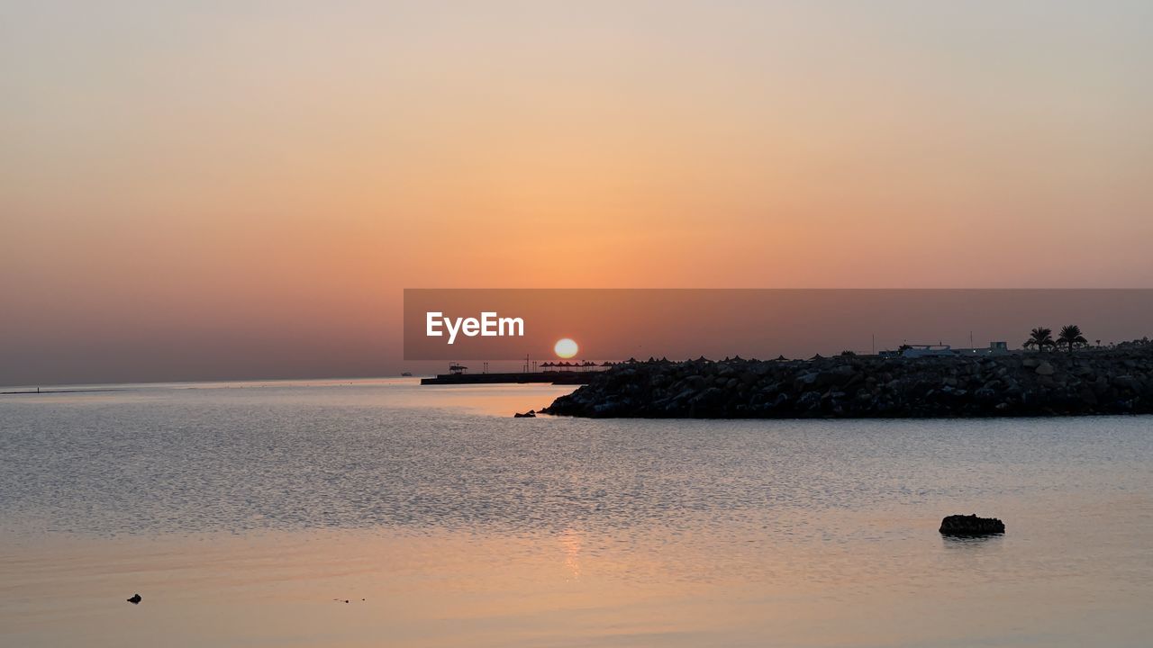 SCENIC VIEW OF BEACH AGAINST SKY DURING SUNSET