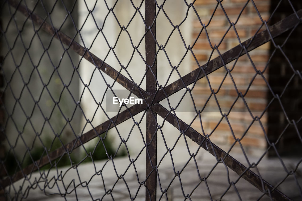 FULL FRAME SHOT OF CHAINLINK FENCE SEEN THROUGH METAL WIRE