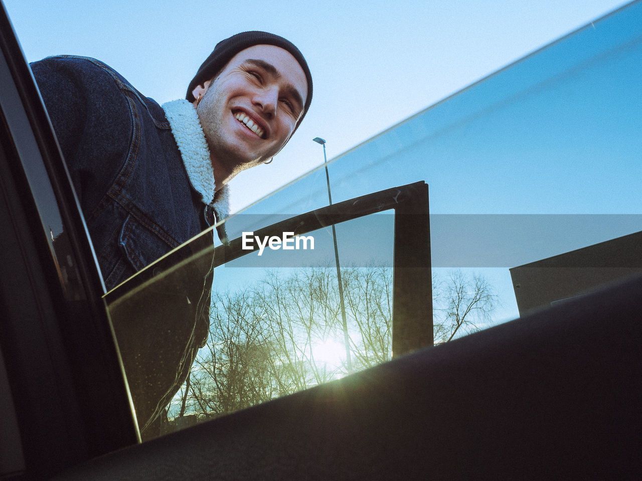 Smiling man seen through car window