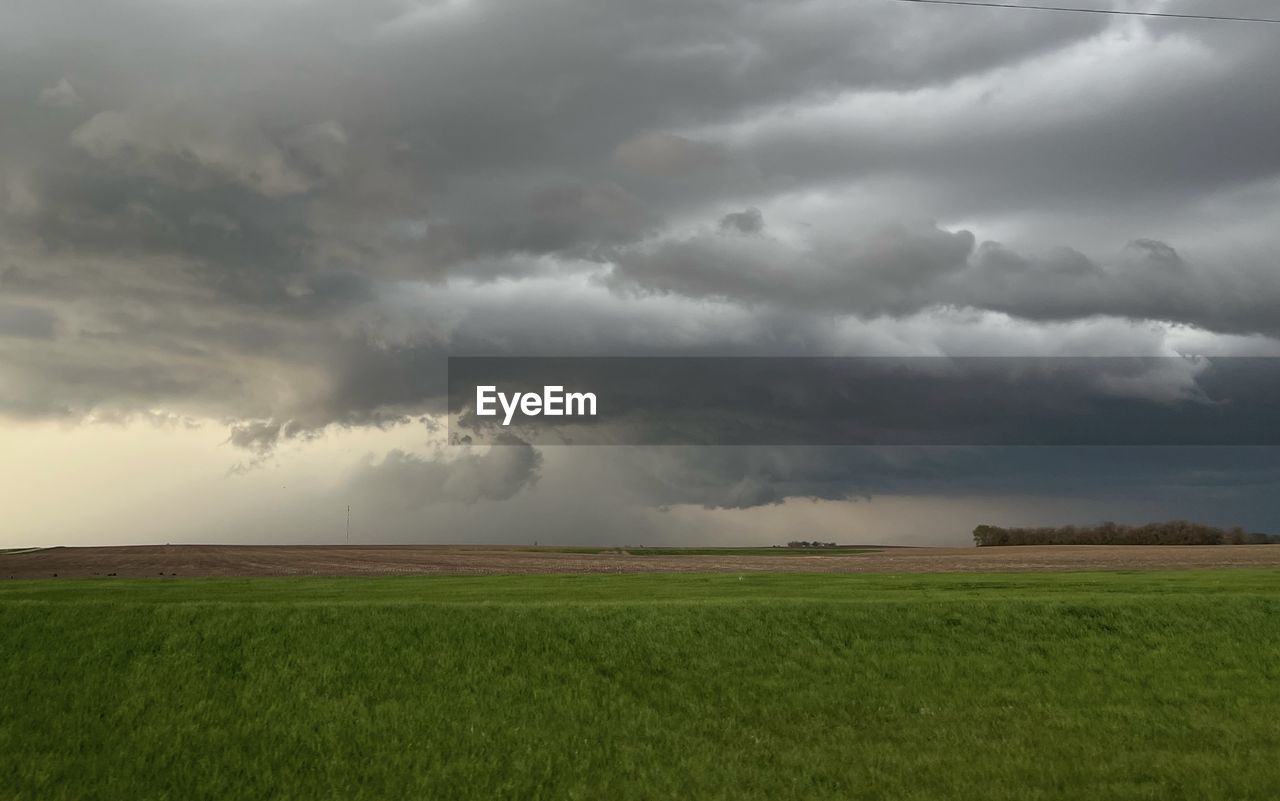 environment, cloud, storm, sky, landscape, thunderstorm, storm cloud, nature, beauty in nature, land, plain, rain, field, plant, wet, dramatic sky, extreme weather, rural scene, no people, horizon over land, scenics - nature, cloudscape, horizon, overcast, wind, monsoon, grassland, grass, agriculture, prairie, outdoors, tornado, torrential rain, day, power in nature, cumulonimbus, green, ominous, awe, crop, cereal plant, warning sign