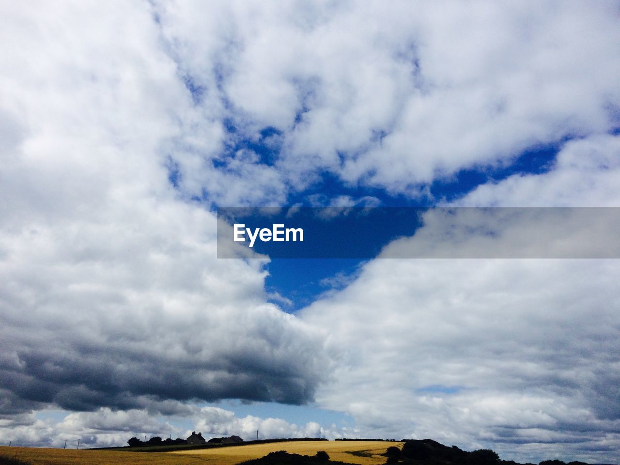 Low angle view of landscape against cloudy sky