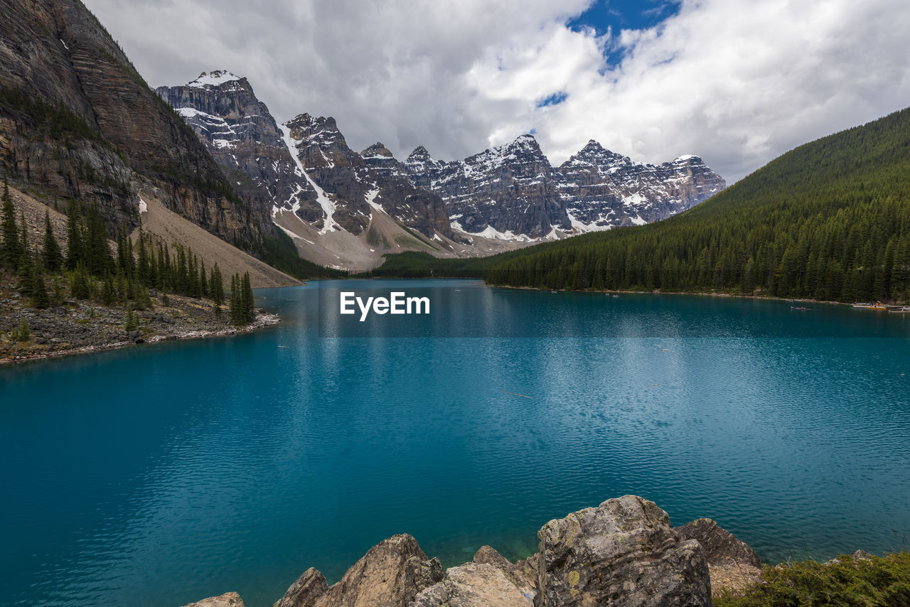 Scenic view of lake by mountains against sky