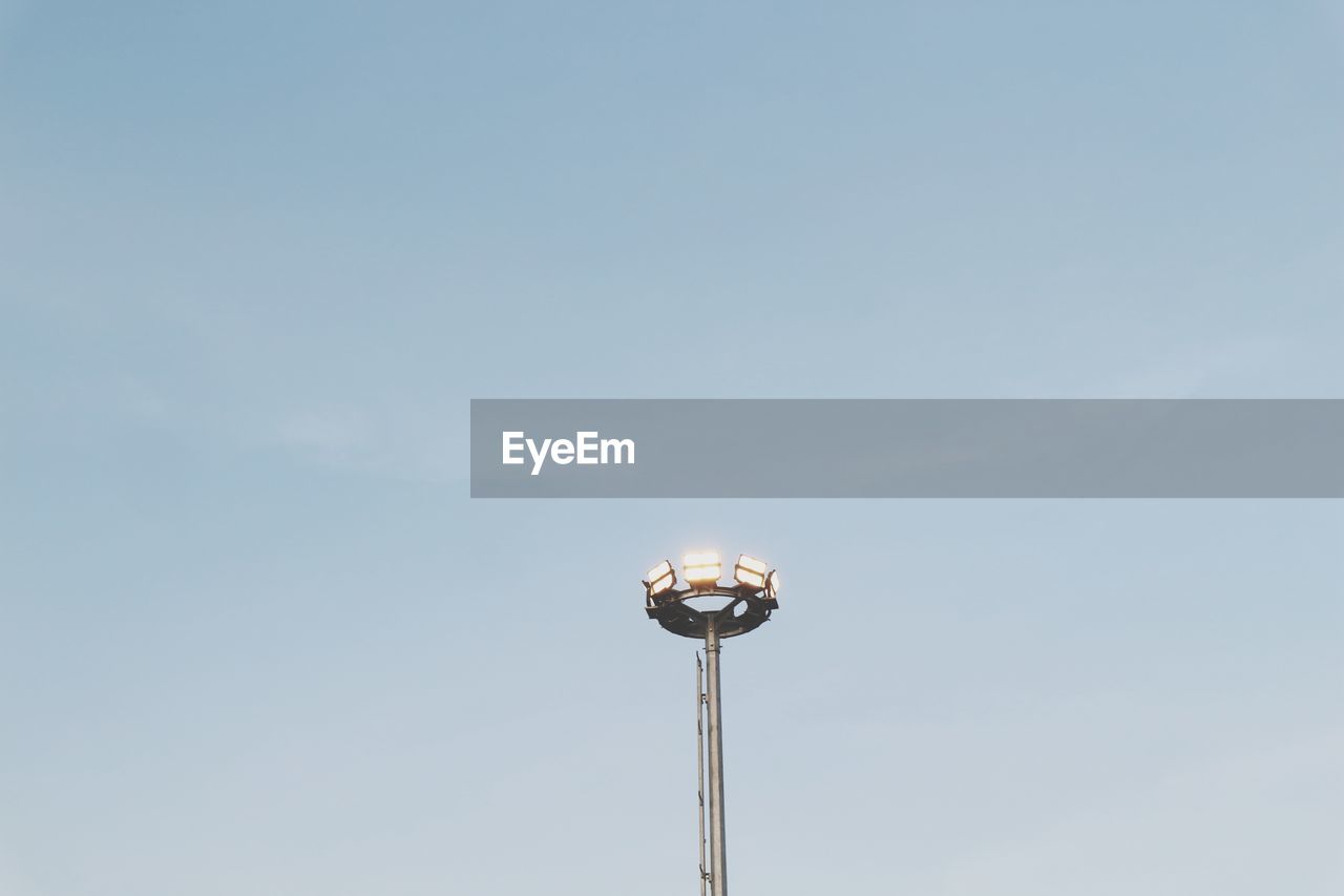 LOW ANGLE VIEW OF ILLUMINATED STREET LIGHT AGAINST BLUE SKY