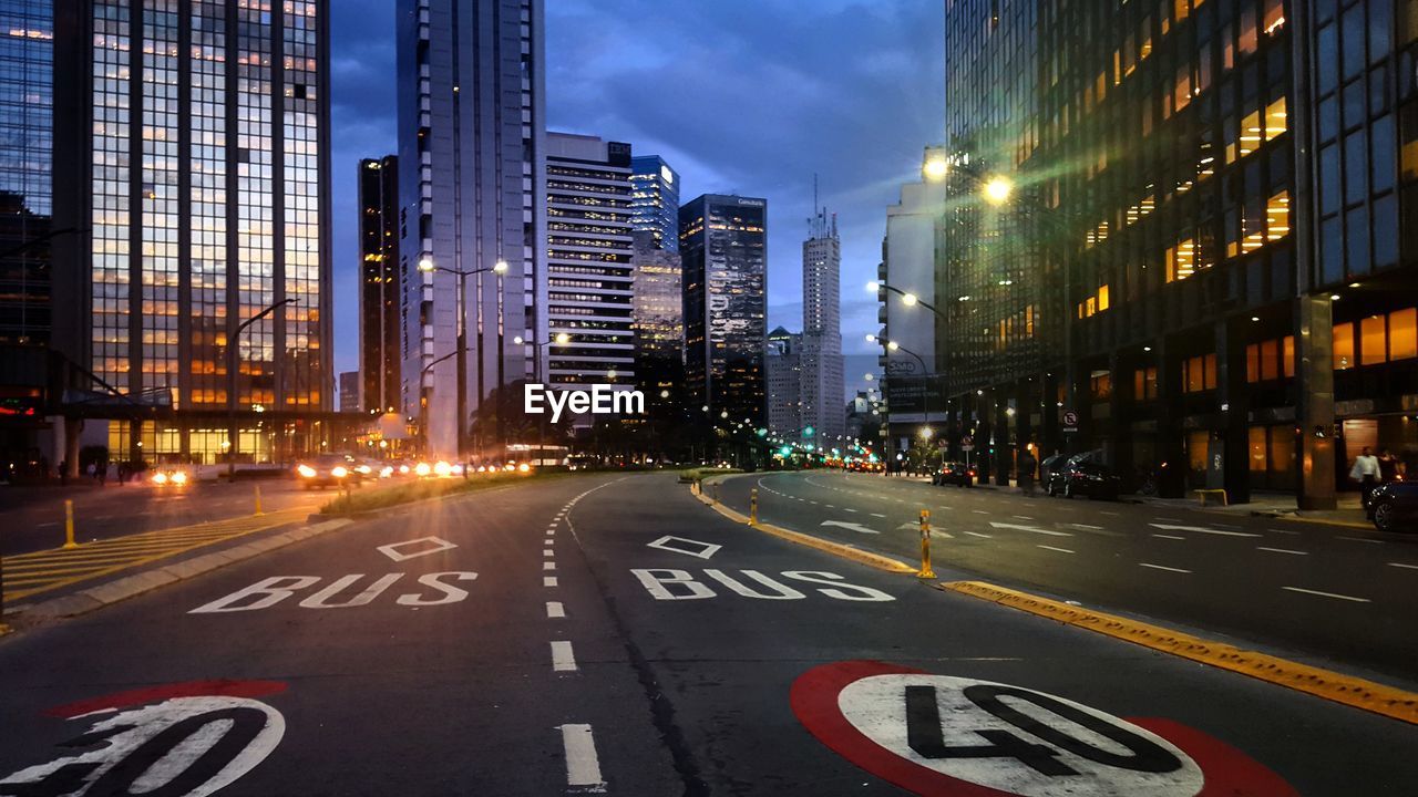 ILLUMINATED CITY STREET AND BUILDINGS AT NIGHT