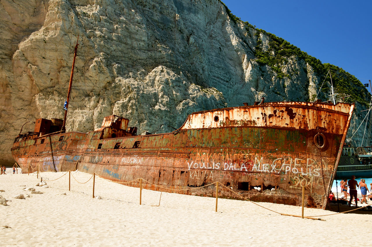 Abandoned boats on beach against sky