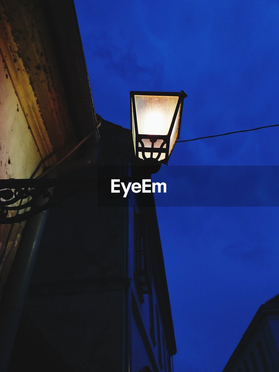 LOW ANGLE VIEW OF ILLUMINATED STREET LIGHT AGAINST BLUE SKY