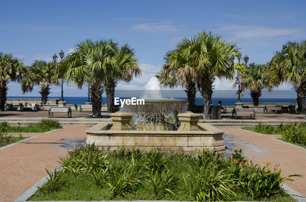 Fountain in park against blue sky