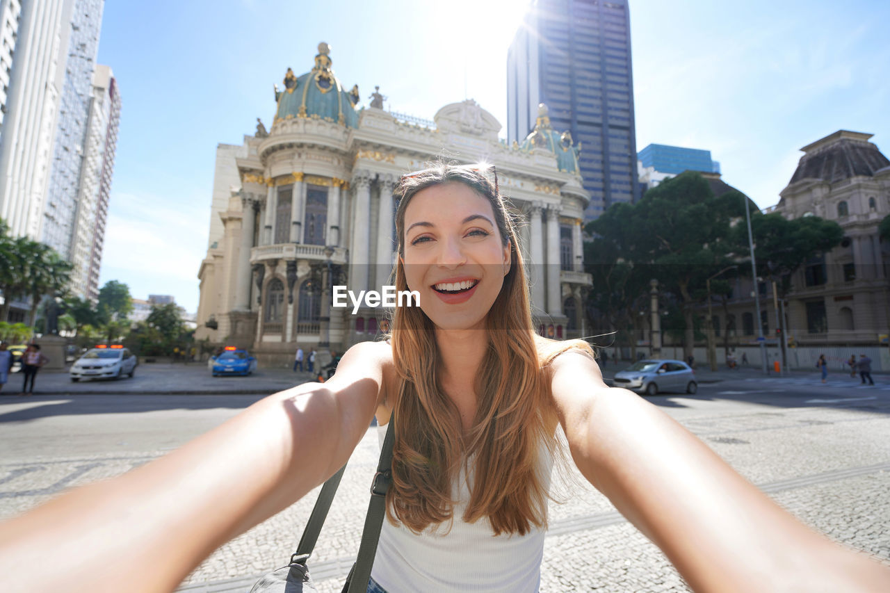 Brazilian young woman takes self portrait in front of the municipal theater of rio de janeiro,brazil