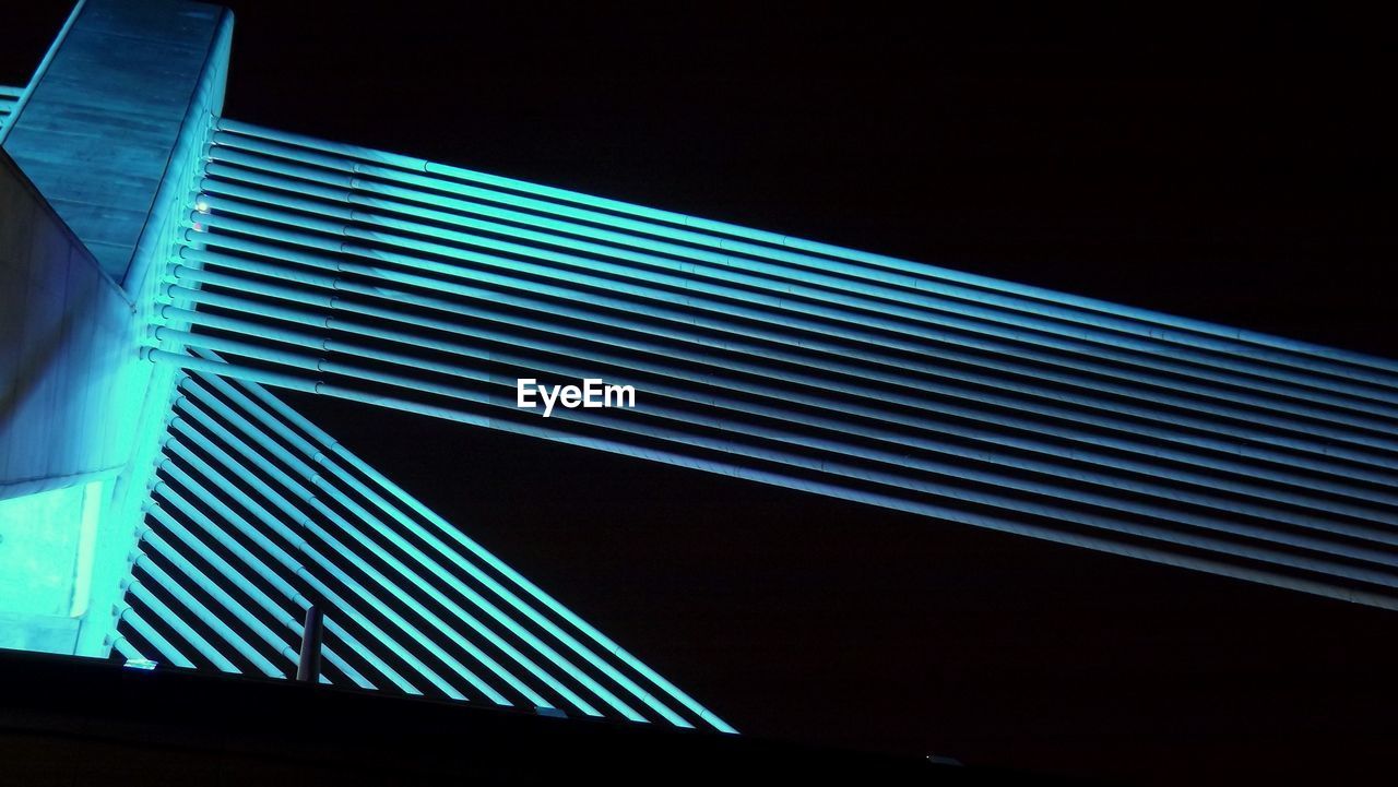 LOW ANGLE VIEW OF ILLUMINATED BUILDINGS AT NIGHT