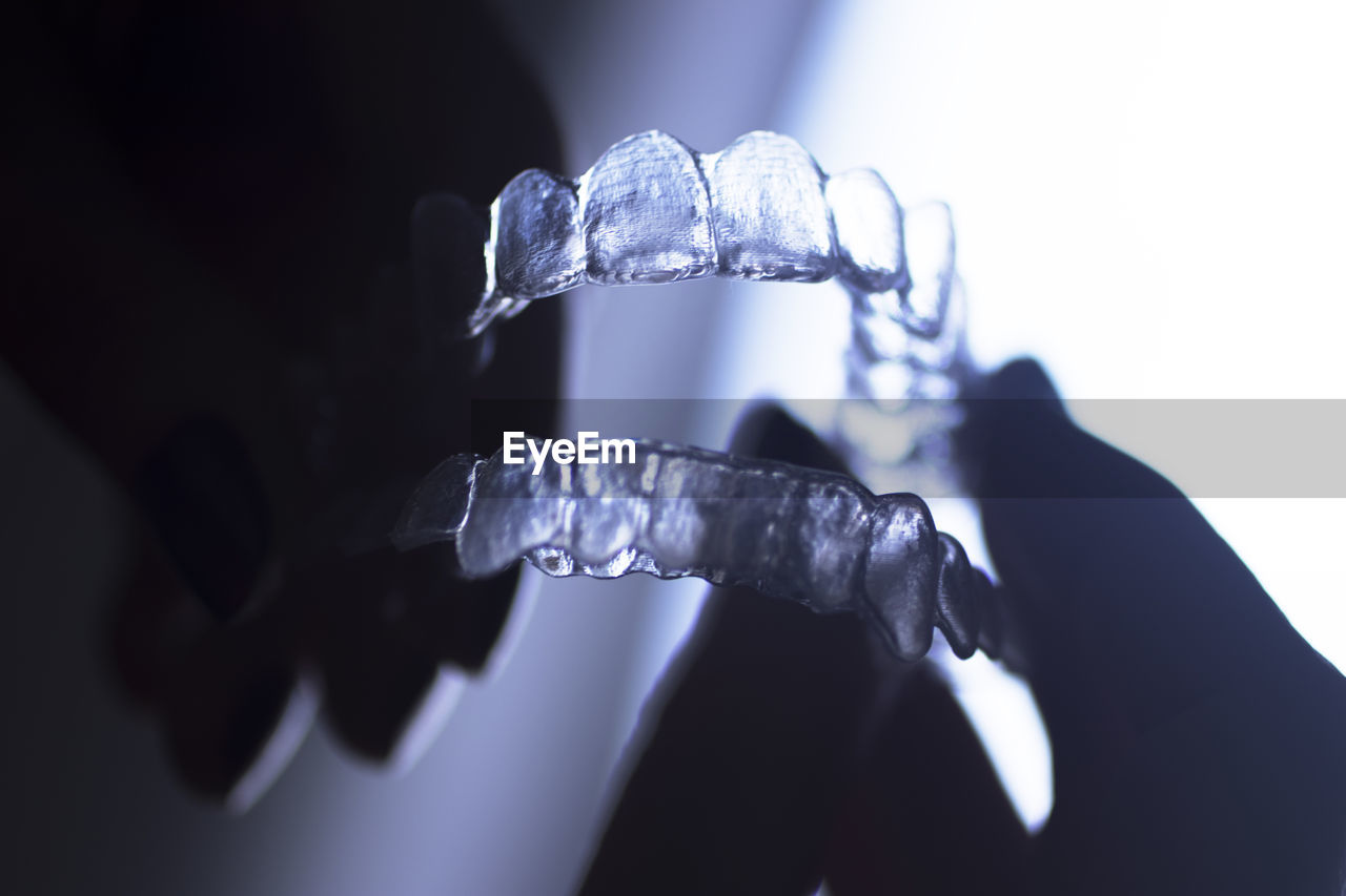 Close-up of hands holding plastic dentures