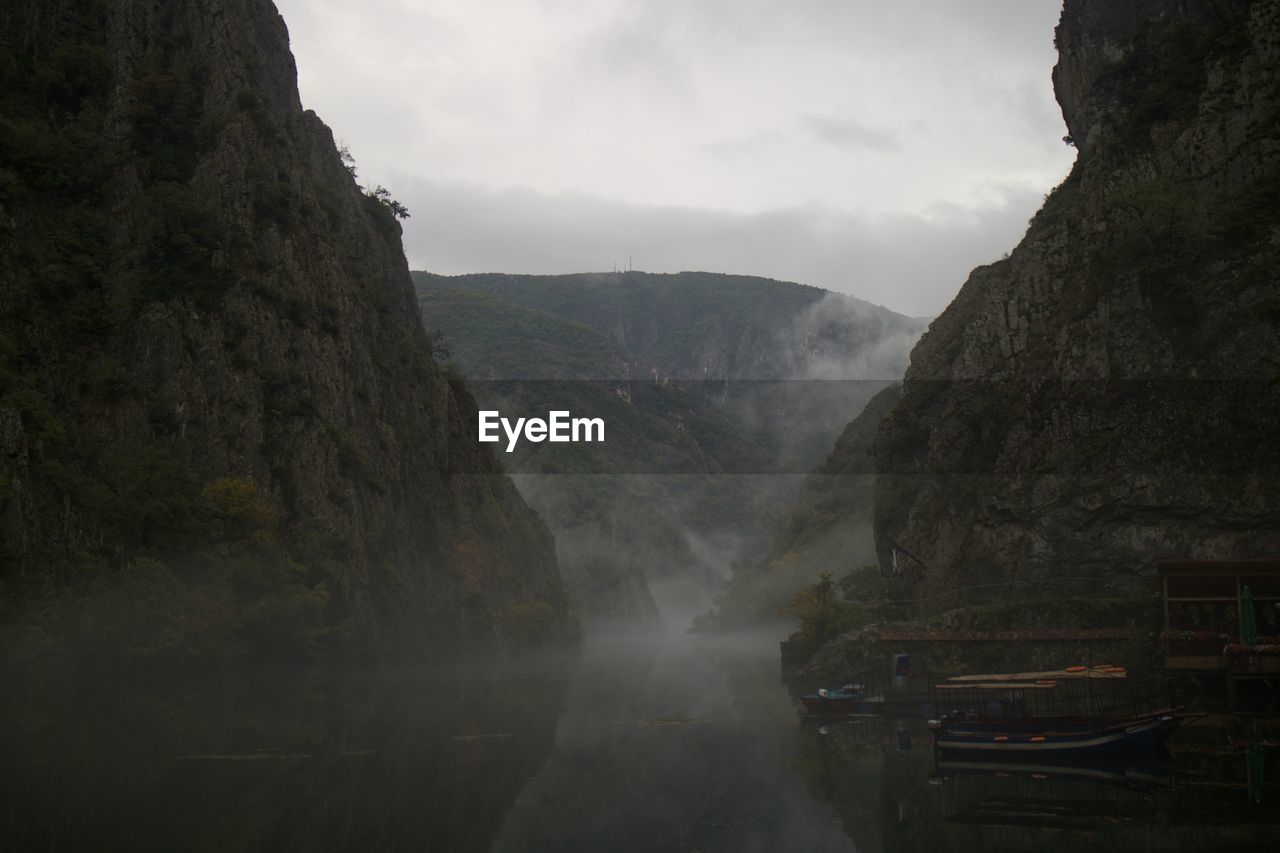 water, environment, fog, nature, scenics - nature, beauty in nature, mountain, landscape, cloud, land, rock, travel, sky, no people, travel destinations, outdoors, river, tranquility, cliff, waterfall, rock formation, tourism, non-urban scene, terrain, tree, reflection, architecture