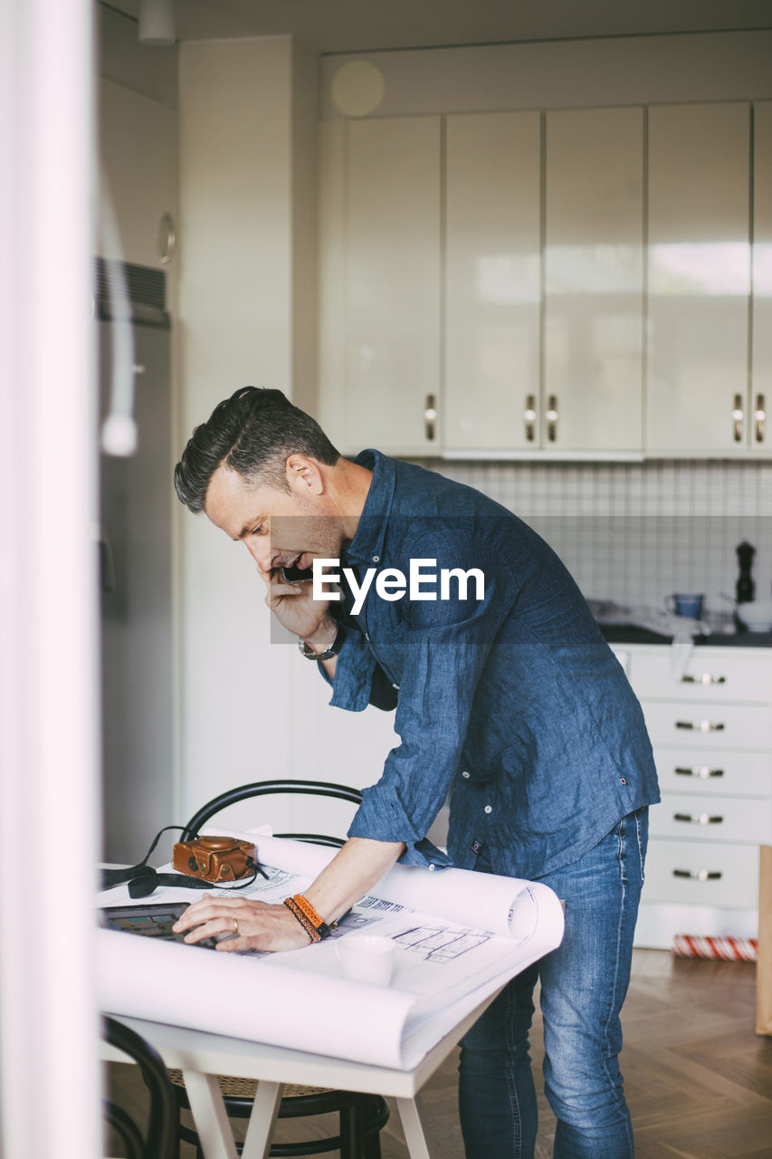 Man working from home talking with coworker on the phone