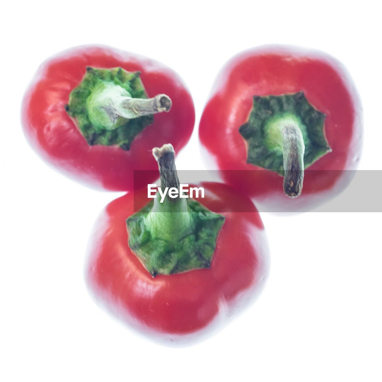 CLOSE-UP OF RED CHILI PEPPERS OVER WHITE BACKGROUND