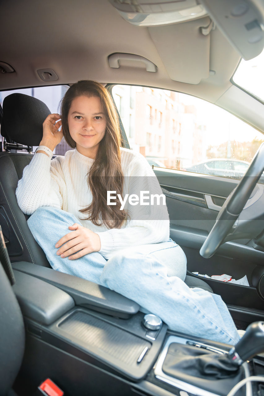 portrait of smiling young woman sitting in car