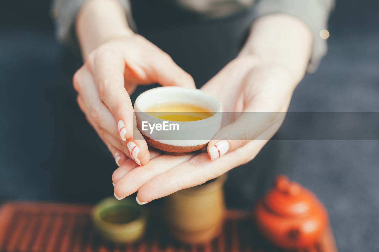 Midsection of woman holding herbal tea 