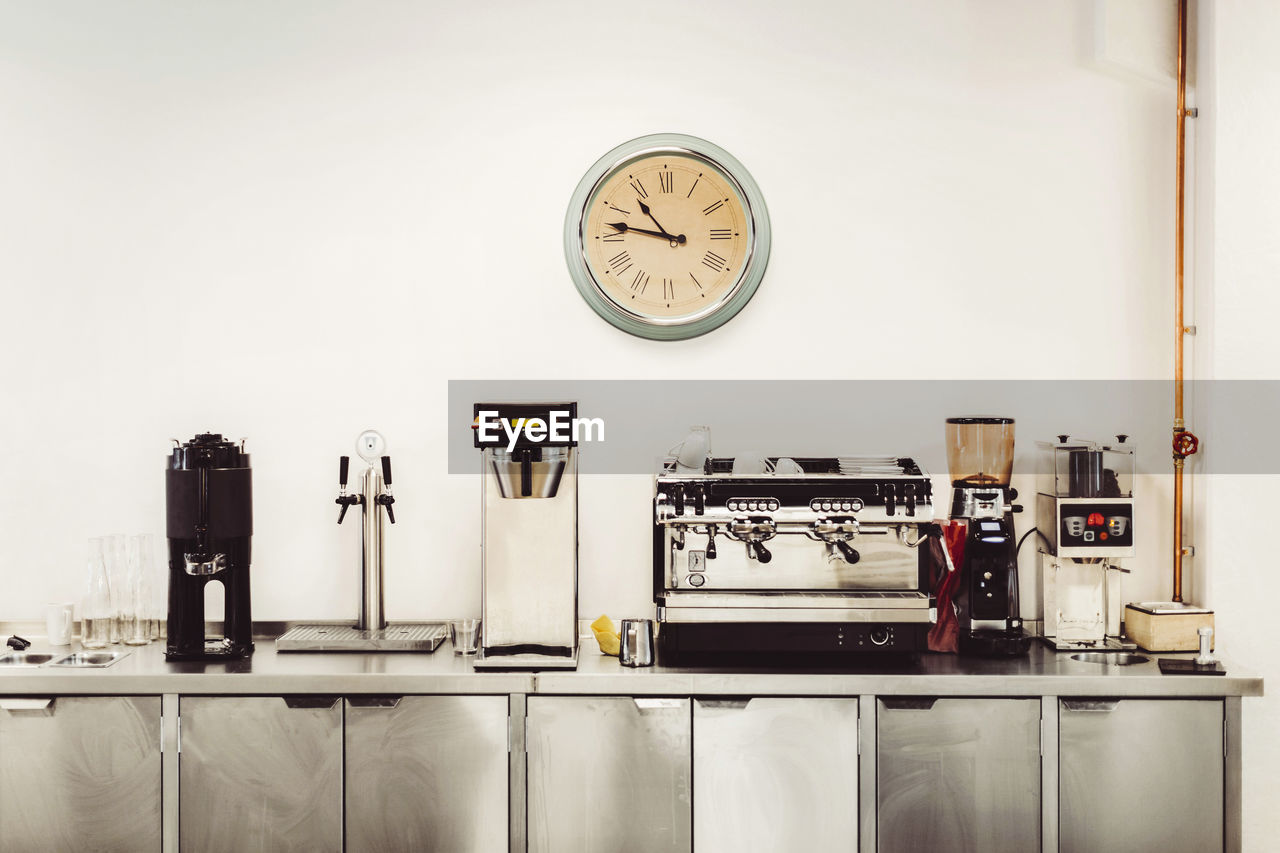 Olika kaffemaskiner och klocka i servering