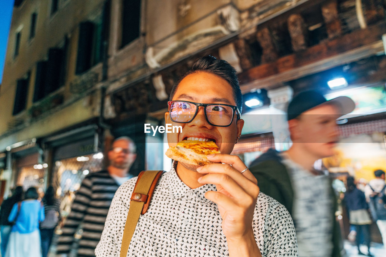 Close-up portrait of man eating in city