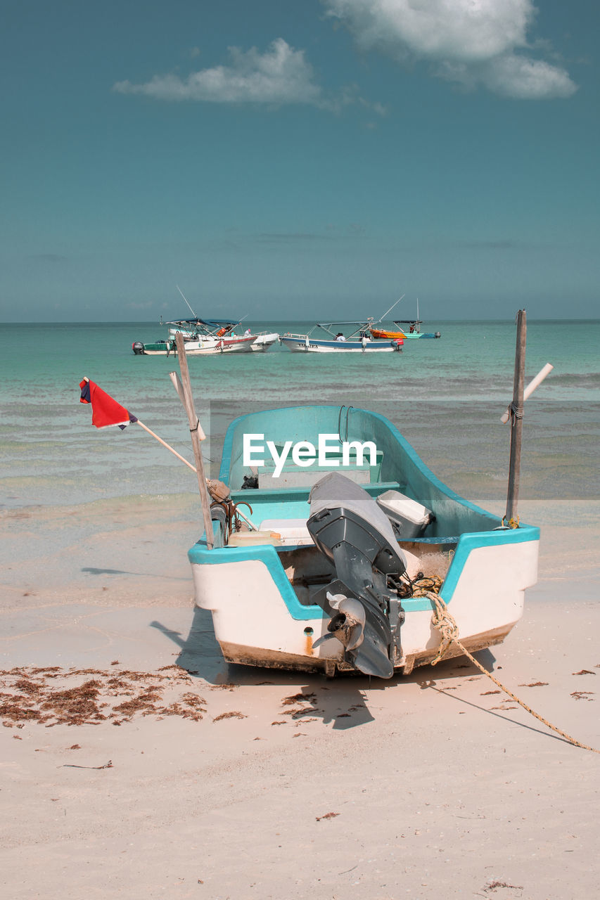 Fishing boats on beach with turquoise sea in the background