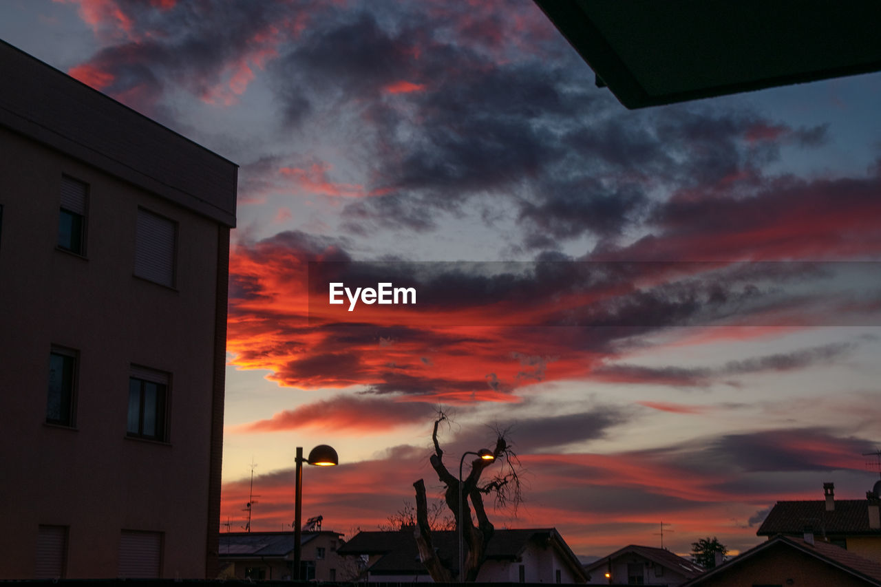 LOW ANGLE VIEW OF BUILDINGS AGAINST SKY DURING SUNSET