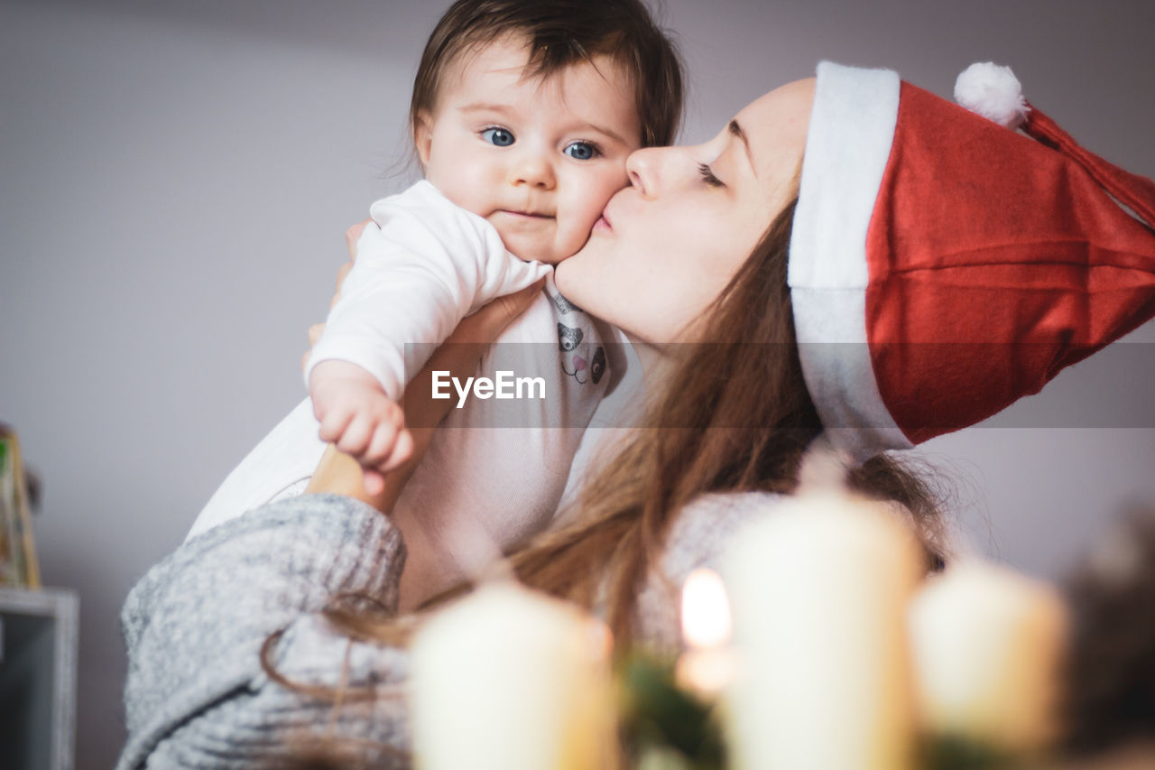 Mother kissing her baby at christmas time
