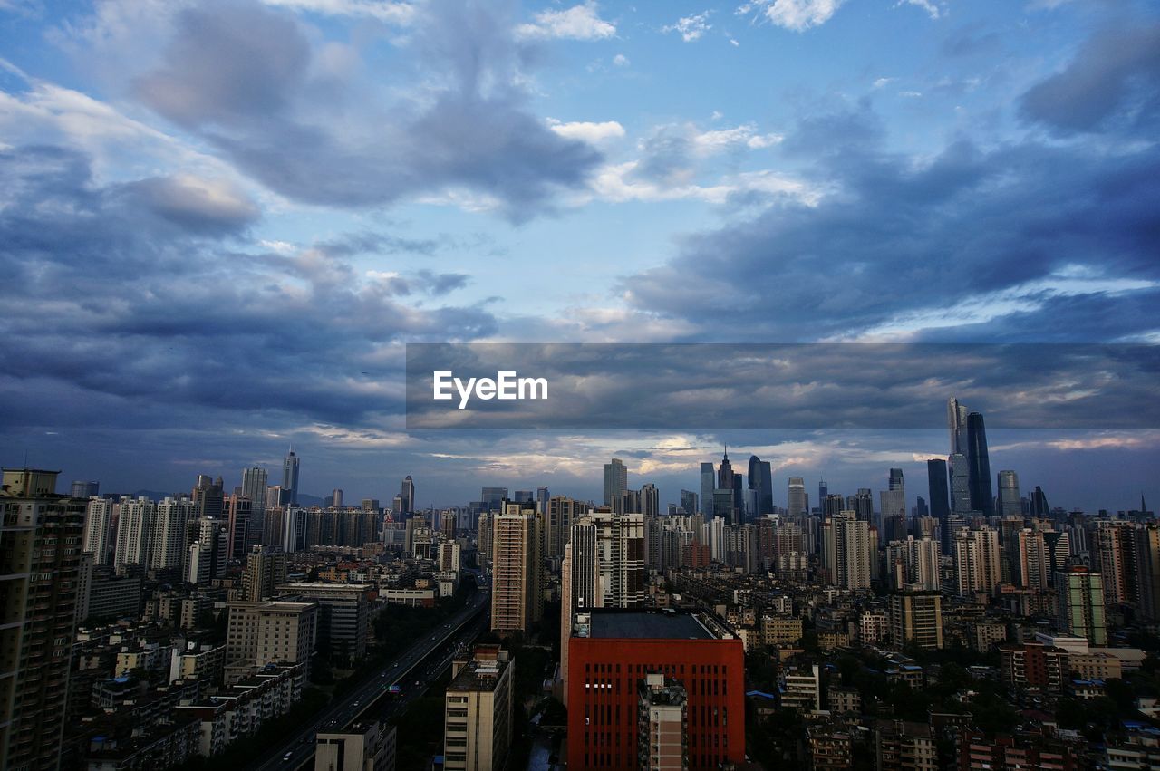 View of cityscape against cloudy sky