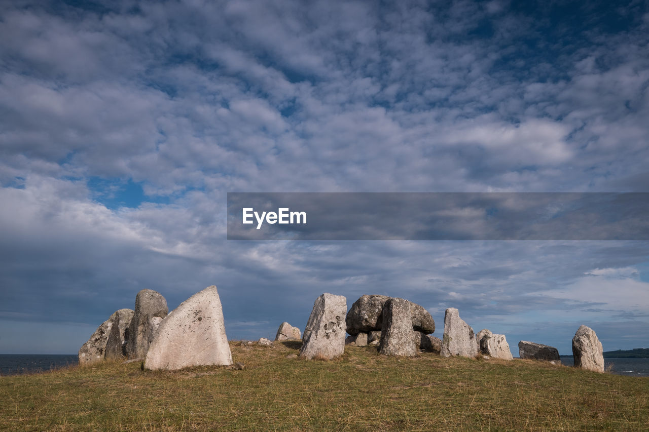 Viking grave at havängsdösen on shoreline of baltic sea with amazing dramatic evening sky