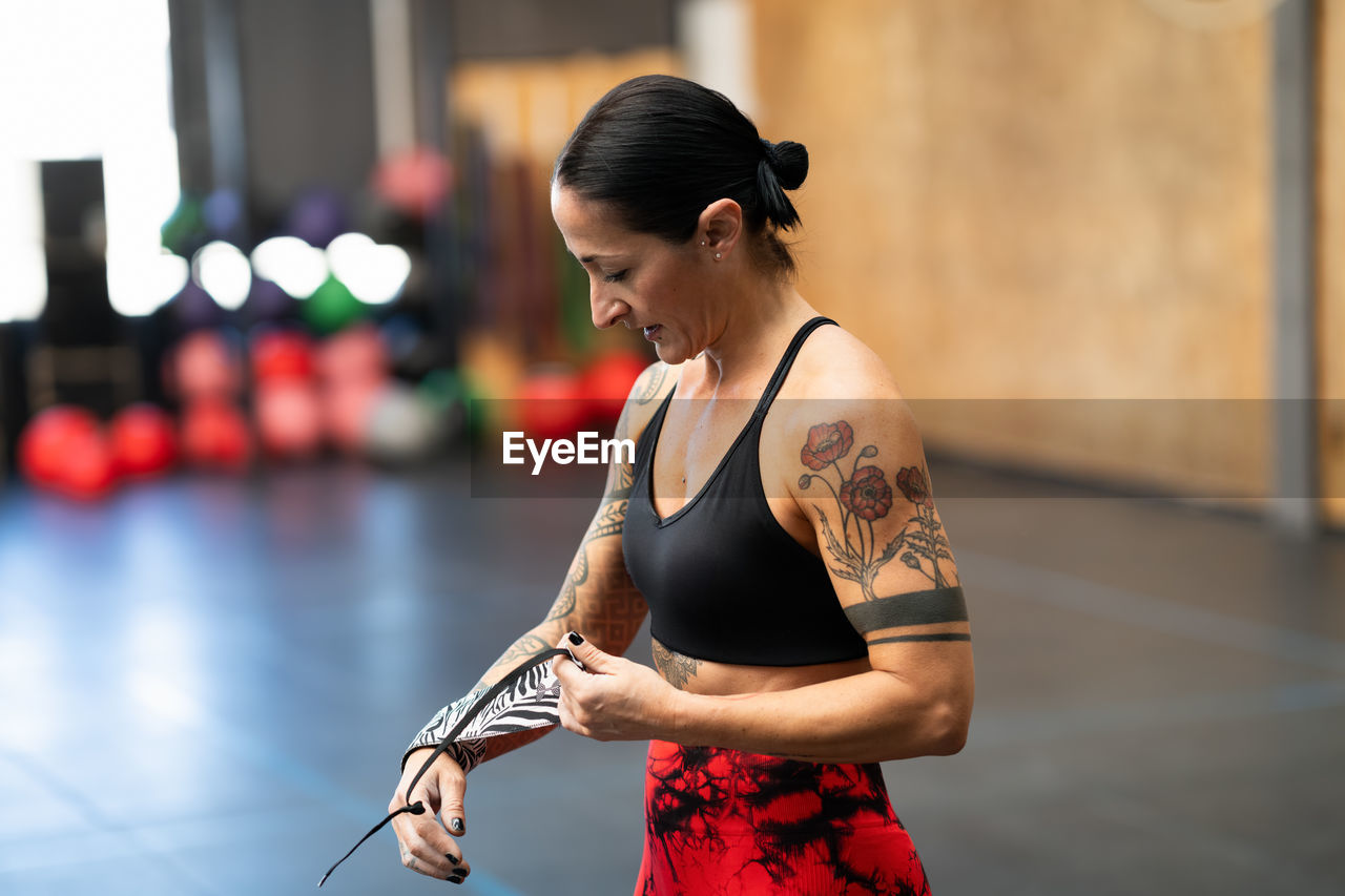 side view of young woman standing in gym