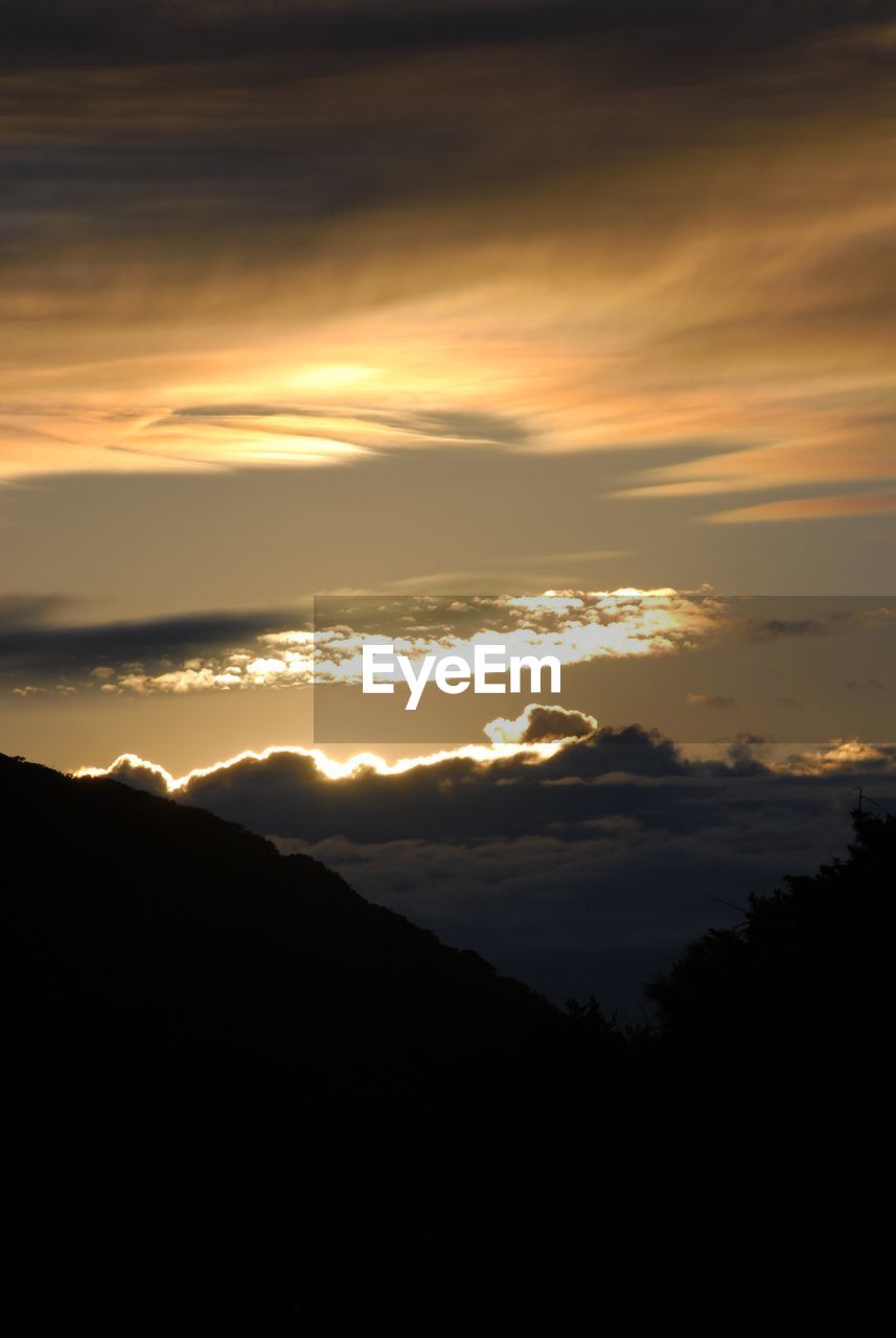 SCENIC VIEW OF SILHOUETTE MOUNTAIN AGAINST DRAMATIC SKY