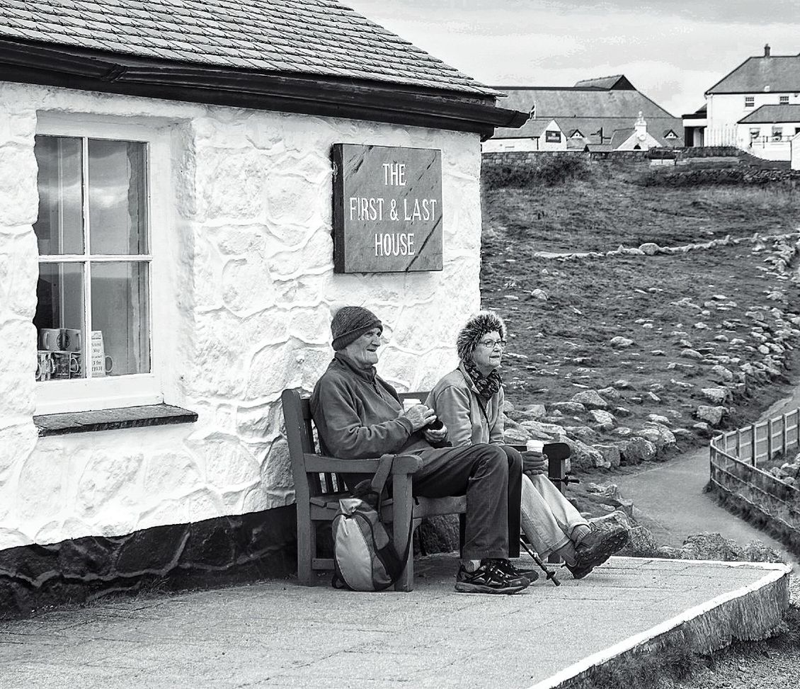 FULL LENGTH OF MAN SITTING AT ROADSIDE