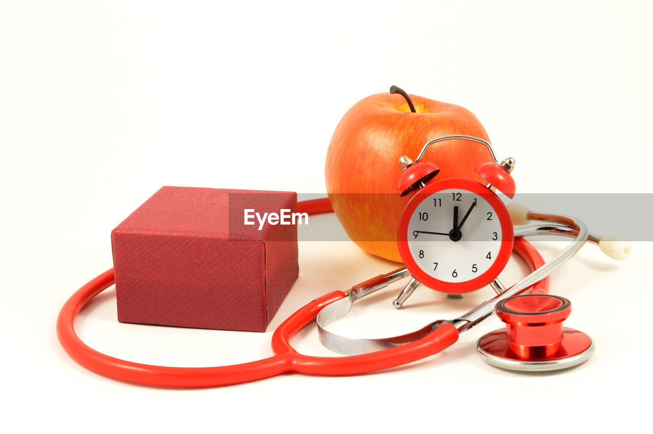 CLOSE-UP OF CLOCK AGAINST ORANGE WALL