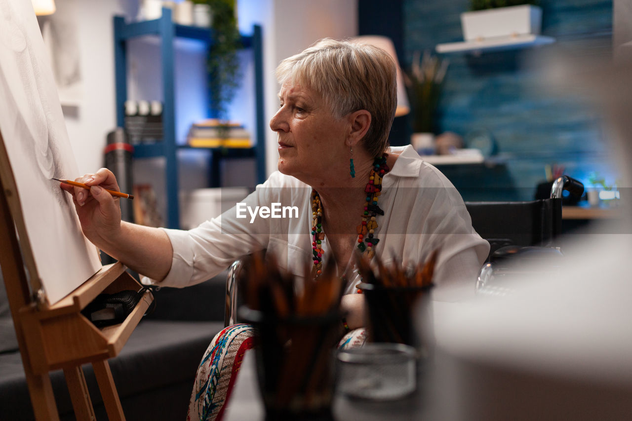 Senior woman painting at home