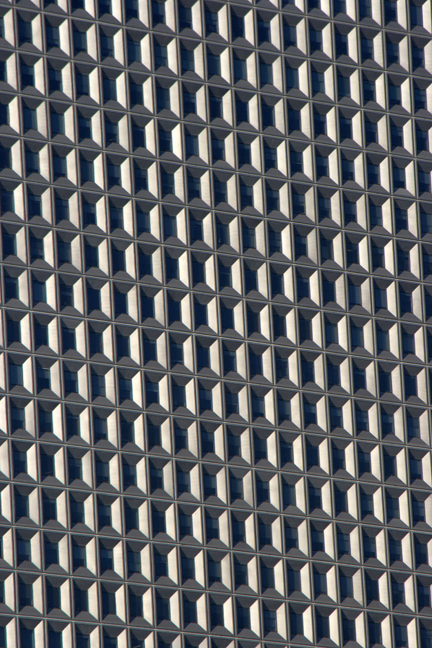 CLOSE-UP OF METAL GRATE AGAINST BUILDING