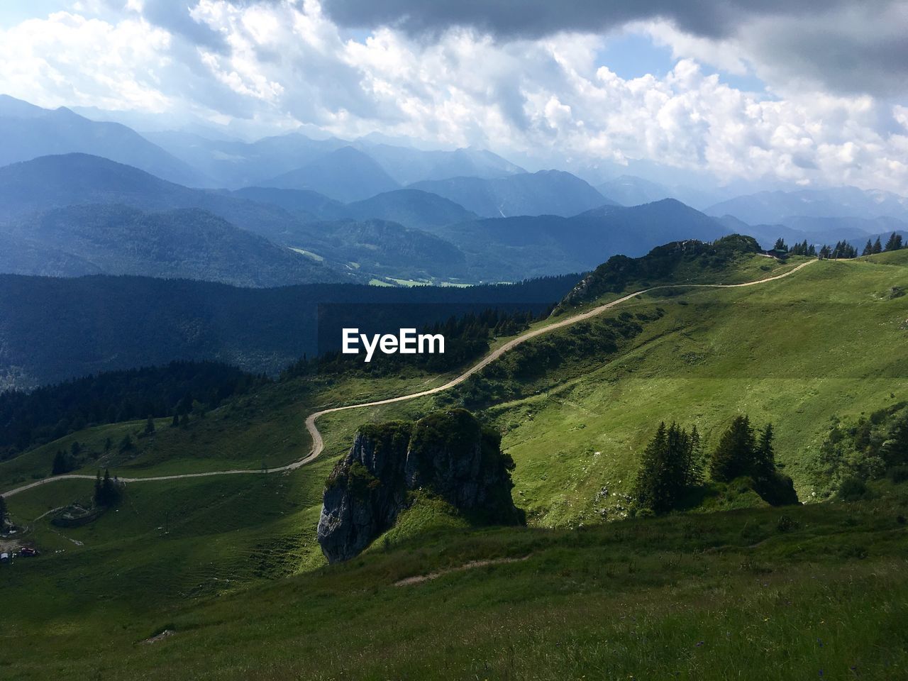 Scenic view of valley and mountains against cloudy sky