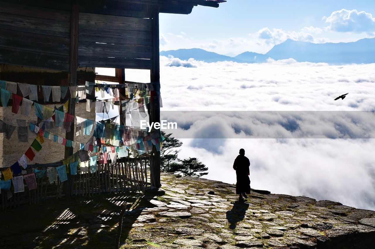 REAR VIEW OF MAN LOOKING AT MOUNTAIN