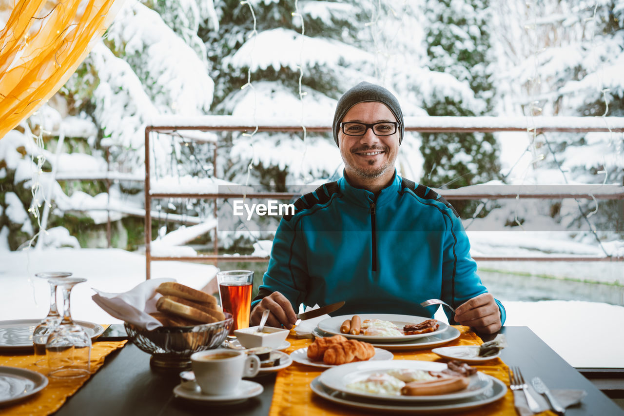 Portrait of smiling man with breakfast on table