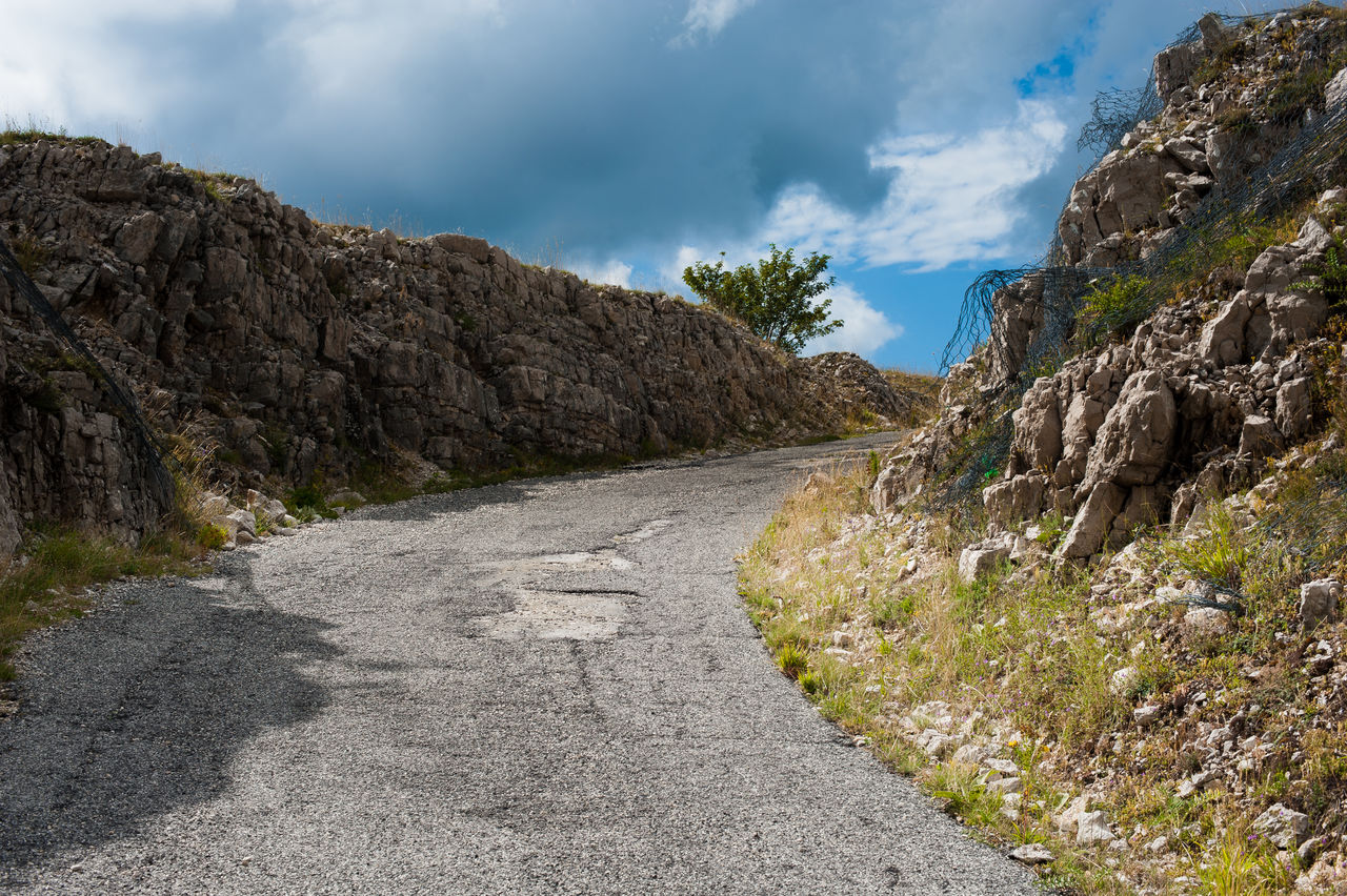 Low angle view of empty road against dramatic sky