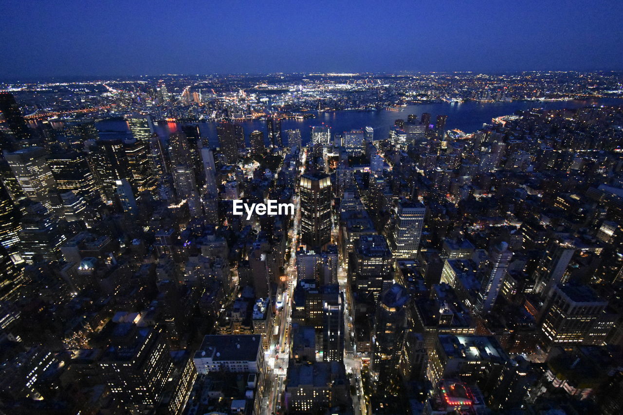 ILLUMINATED CITY AGAINST SKY AT NIGHT