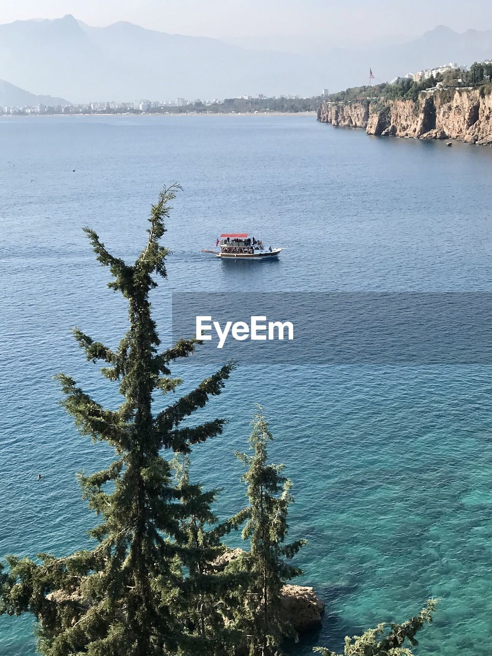 HIGH ANGLE VIEW OF BOATS SAILING IN SEA