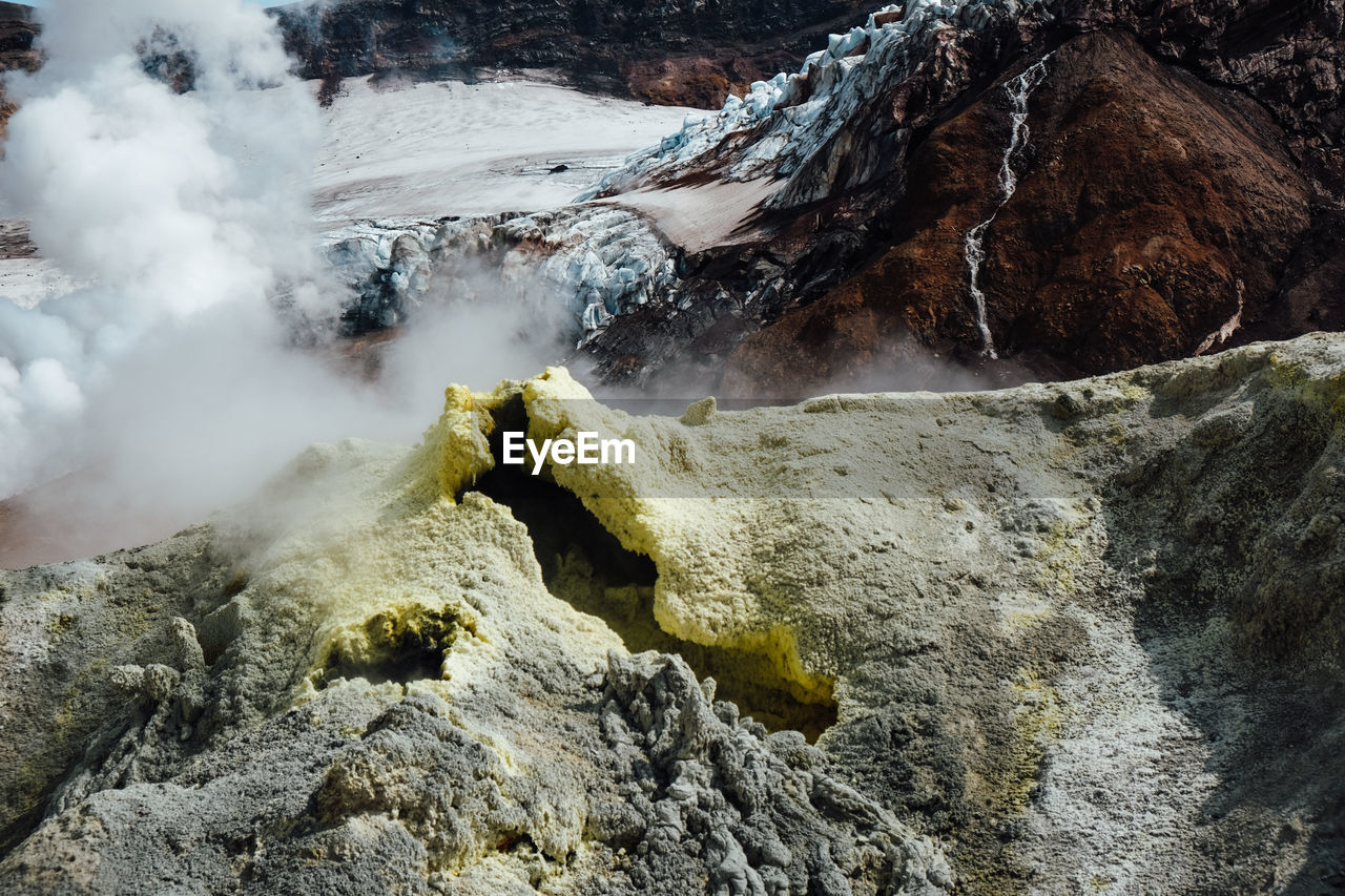 environment, beauty in nature, geology, mountain, landscape, scenics - nature, nature, rock, non-urban scene, wilderness, steam, smoke, volcano, physical geography, land, no people, travel destinations, travel, power in nature, sulphur, outdoors, water, high angle view, volcanic crater, heat, day, activity, hot spring, tourism, adventure, mountain range, extreme terrain, fog, rock formation