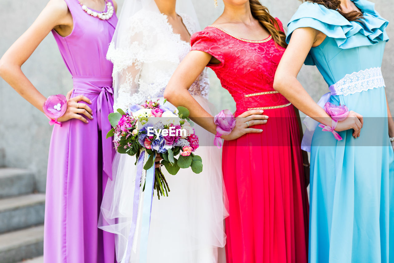 midsection of bride and bridegroom holding hands